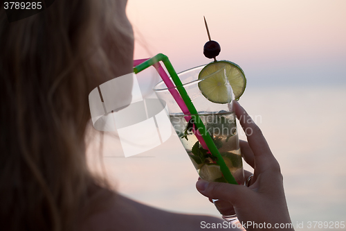 Image of Woman drinking mojito cocktail