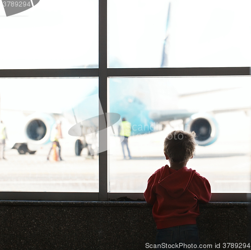 Image of Boy looks at the plane at the airport