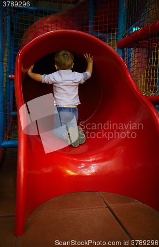 Image of Boy is sitting at the slide hole