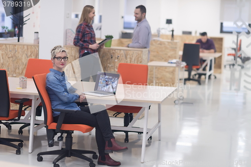 Image of portrait of young business woman at office with team in backgrou