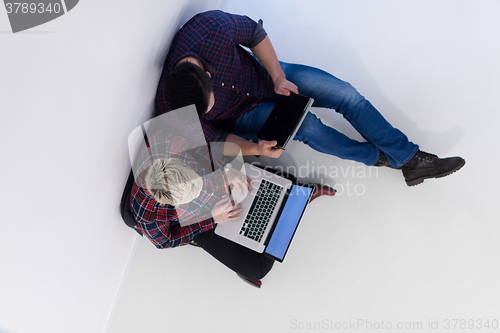 Image of top view of  couple working on laptop computer at startup office