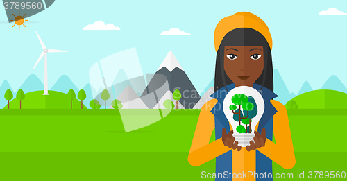 Image of Woman with lightbulb and trees inside.