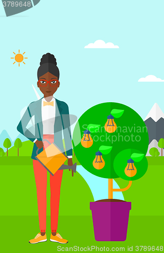 Image of Woman watering tree with light bulbs.