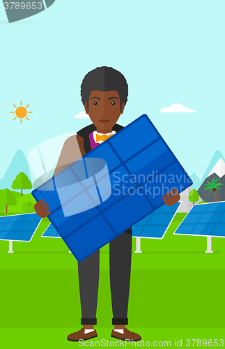 Image of Man holding solar panel.