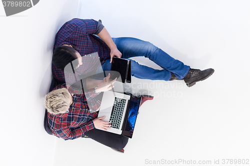 Image of top view of  couple working on laptop computer at startup office