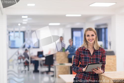 Image of portrait of young business woman at office with team in backgrou