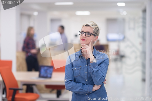 Image of portrait of young business woman at office with team in backgrou