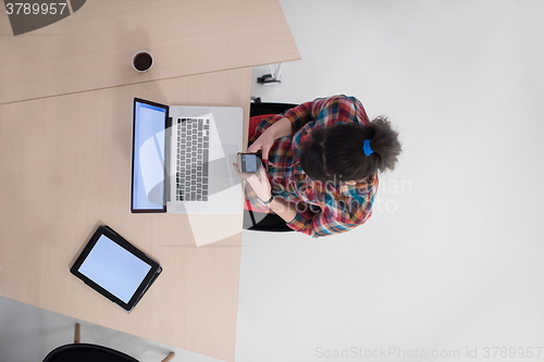 Image of top view of young business woman working on laptop