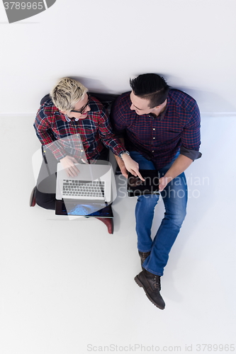 Image of top view of  couple working on laptop computer at startup office