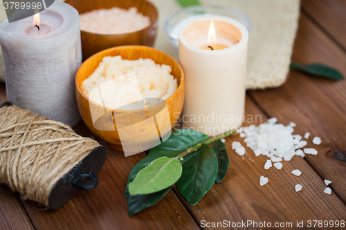 Image of close up of natural body scrub and candles on wood