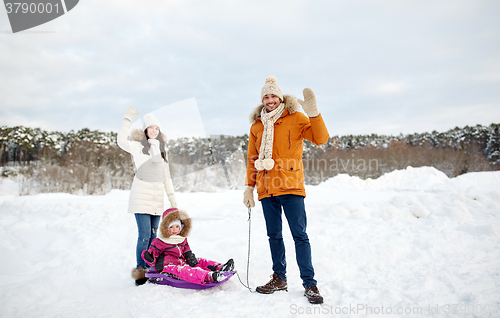 Image of happy family with sled walking in winter outdoors