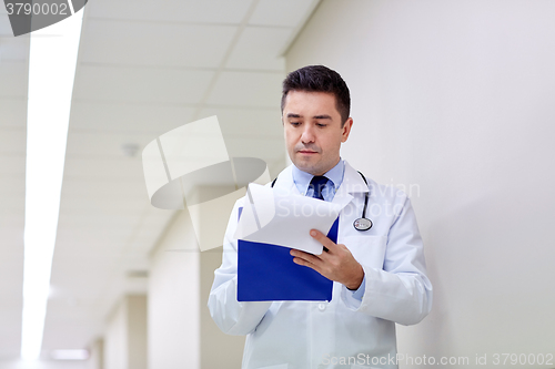 Image of doctor with clipboard at hospital corridor