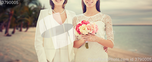 Image of close up of happy lesbian couple with flowers