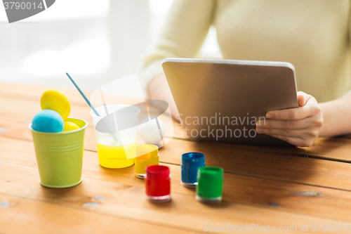 Image of close up of woman with tablet pc and easter eggs