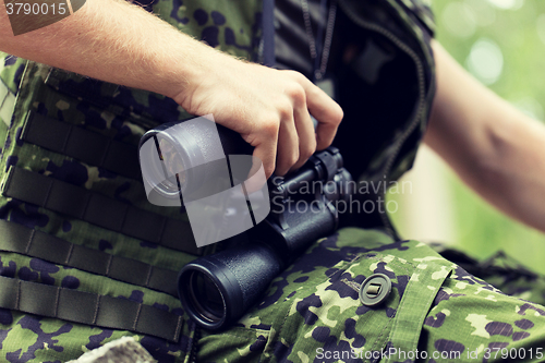 Image of close up of soldier or hunter with binocular