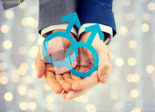 Image of close up of happy male gay couple with love symbol