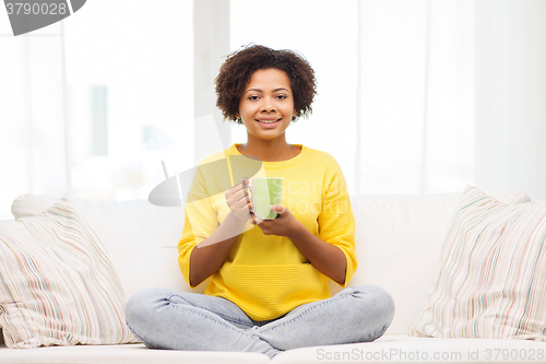 Image of happy african american woman drinking from tea cup