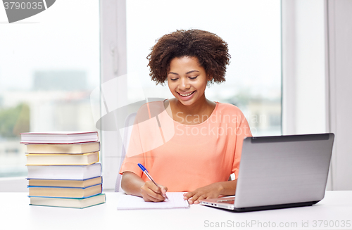 Image of happy african american woman with laptop at home