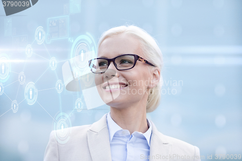 Image of young smiling businesswoman in eyeglasses outdoors