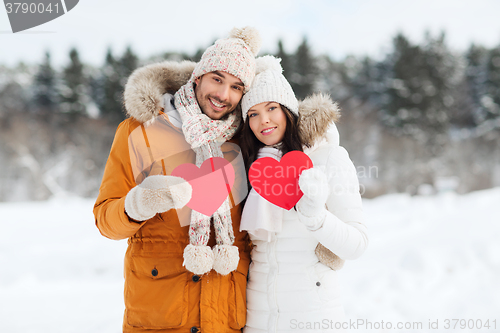 Image of happy couple with red hearts over winter landscape