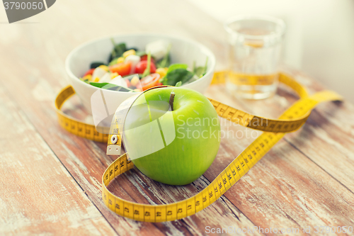 Image of close up of green apple and measuring tape