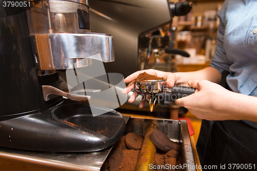 Image of close up of woman making coffee by machine at cafe