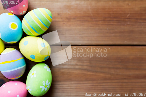 Image of close up of colored easter eggs on wooden surface