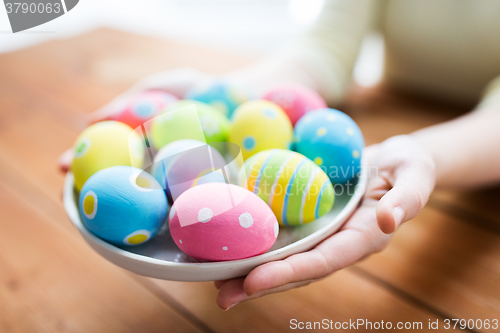 Image of close up of woman hands with colored easter eggs