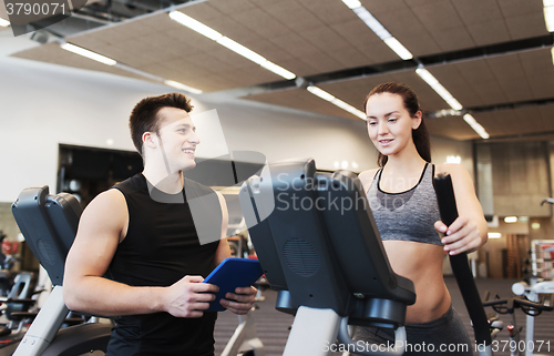 Image of woman with trainer exercising on stepper in gym