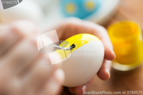 Image of close up of woman hands coloring easter eggs