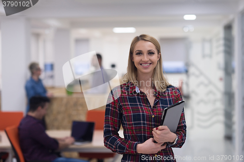 Image of portrait of young business woman at office with team in backgrou