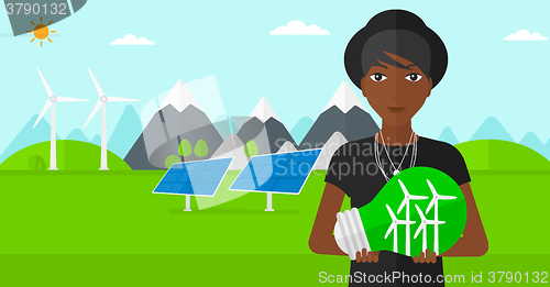 Image of Woman holding lightbulb with windmills inside.