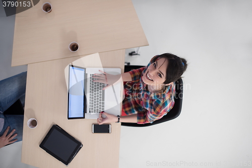 Image of top view of young business woman working on laptop