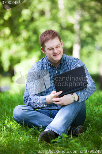 Image of Businessman working in the park.