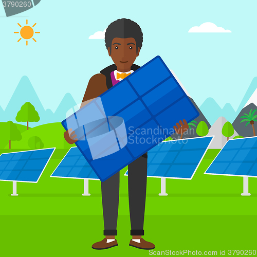 Image of Man holding solar panel.