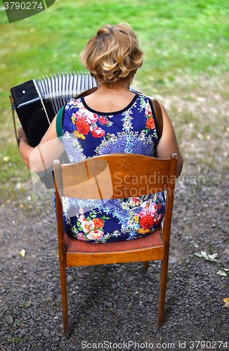 Image of Unidentified woman from behind playing the accordion