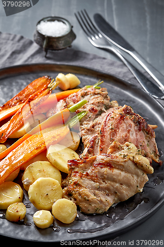 Image of chicken meat and roasted vegetables on gray plate