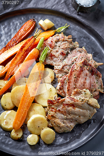 Image of chicken meat and roasted vegetables on gray plate