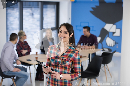 Image of portrait of young business woman at office with team in backgrou