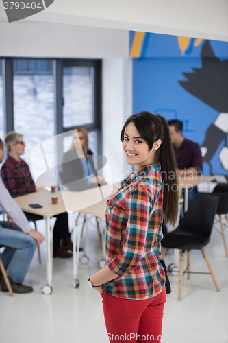 Image of portrait of young business woman at office with team in backgrou