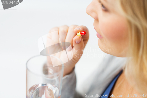 Image of close up of woman taking medicine in pill