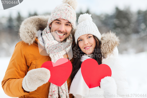 Image of happy couple with red hearts over winter landscape