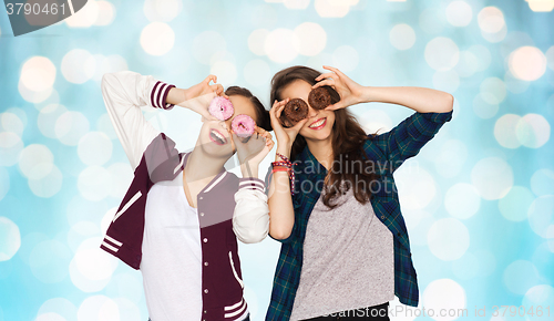 Image of happy pretty teenage girls with donuts having fun