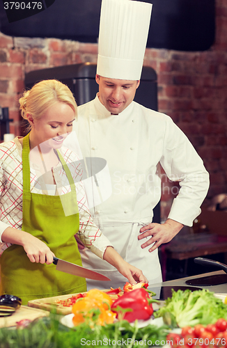 Image of happy male chef cook with woman cooking in kitchen