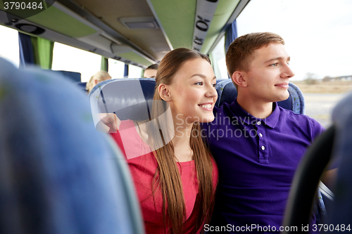 Image of happy teenage couple or passengers in travel bus