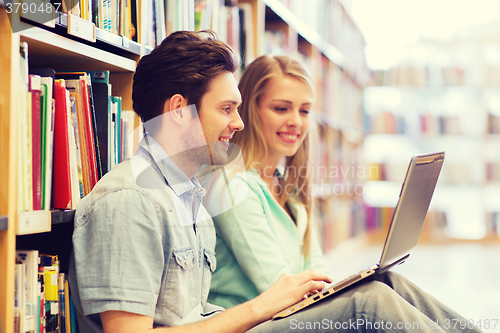 Image of happy students with laptop in library