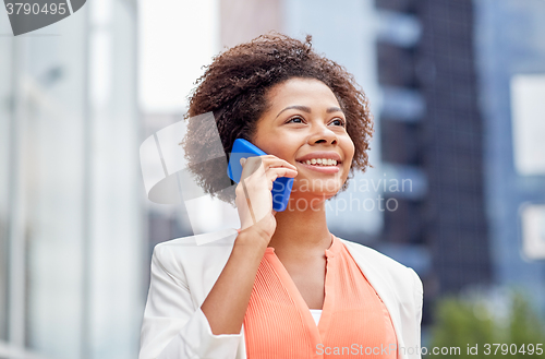 Image of happy african businesswoman calling on smartphone