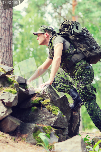 Image of young soldier with backpack in forest