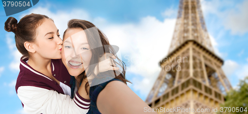 Image of teenage girls taking selfie over eiffel tower