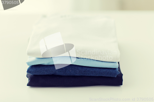 Image of close up of ironed and folded t-shirts on table